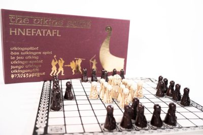 Hnefatafl spelbox och uppdukning med resinpjäser på linnetygsbräde.
